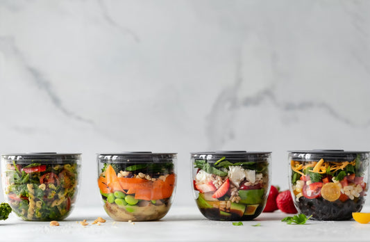 four different salads stored in containers ready to take